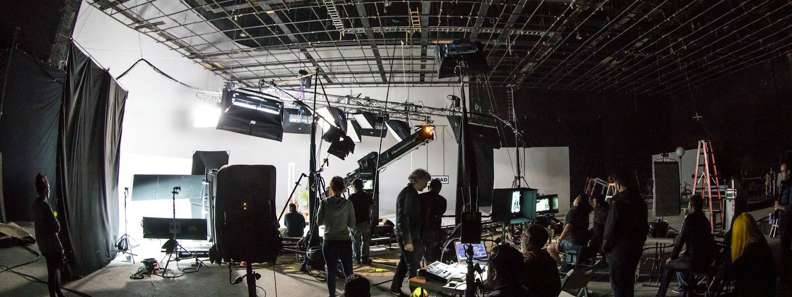 Film crew working on a lit studio set