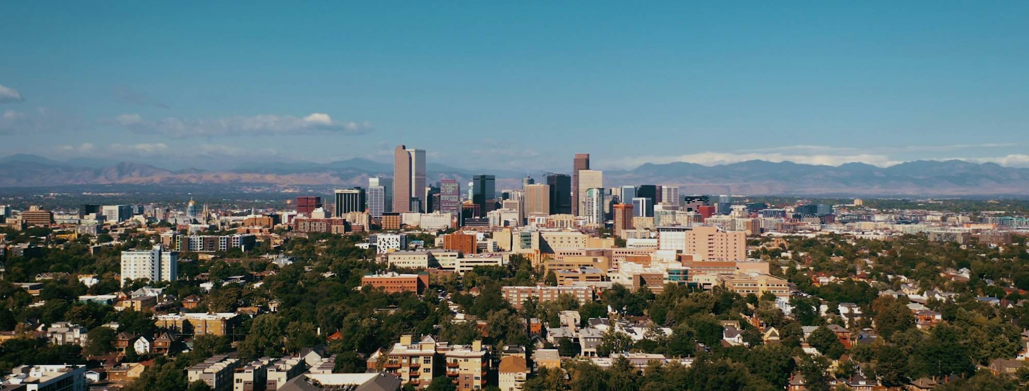 Downtown Denver skyline with the Rocky Mountains behind it
