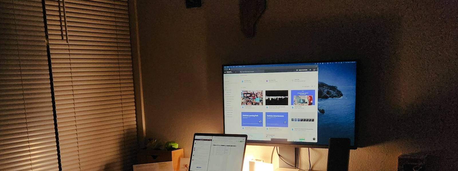 Desk at night with a monitor showing a web design project